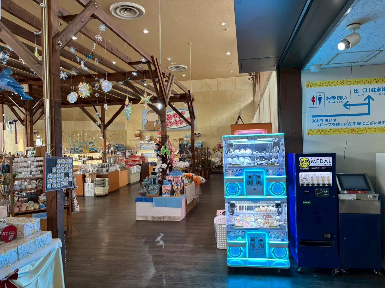 水族館の売店に設置された小型クレーンゲーム機と記念メダル機