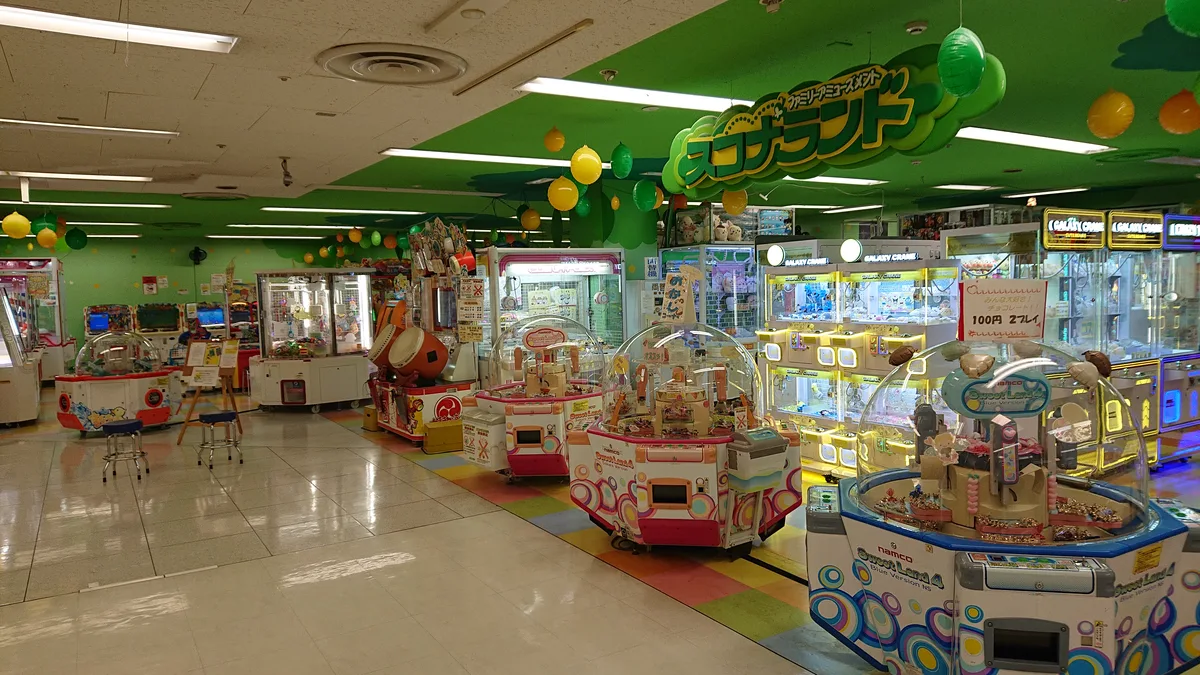 緑の装飾とドーム型クレーンゲーム機が並ぶ広い店内