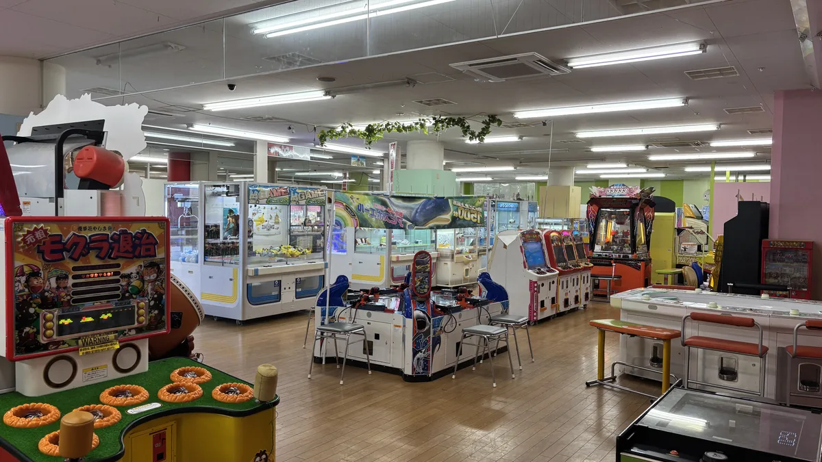 スコナランド新座店の店内。通路沿いにクレーンゲーム機やアーケード機が並ぶ